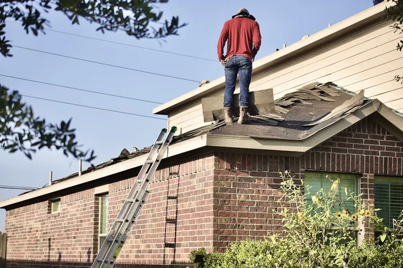 Professional roofer working on a residential roof in Harper